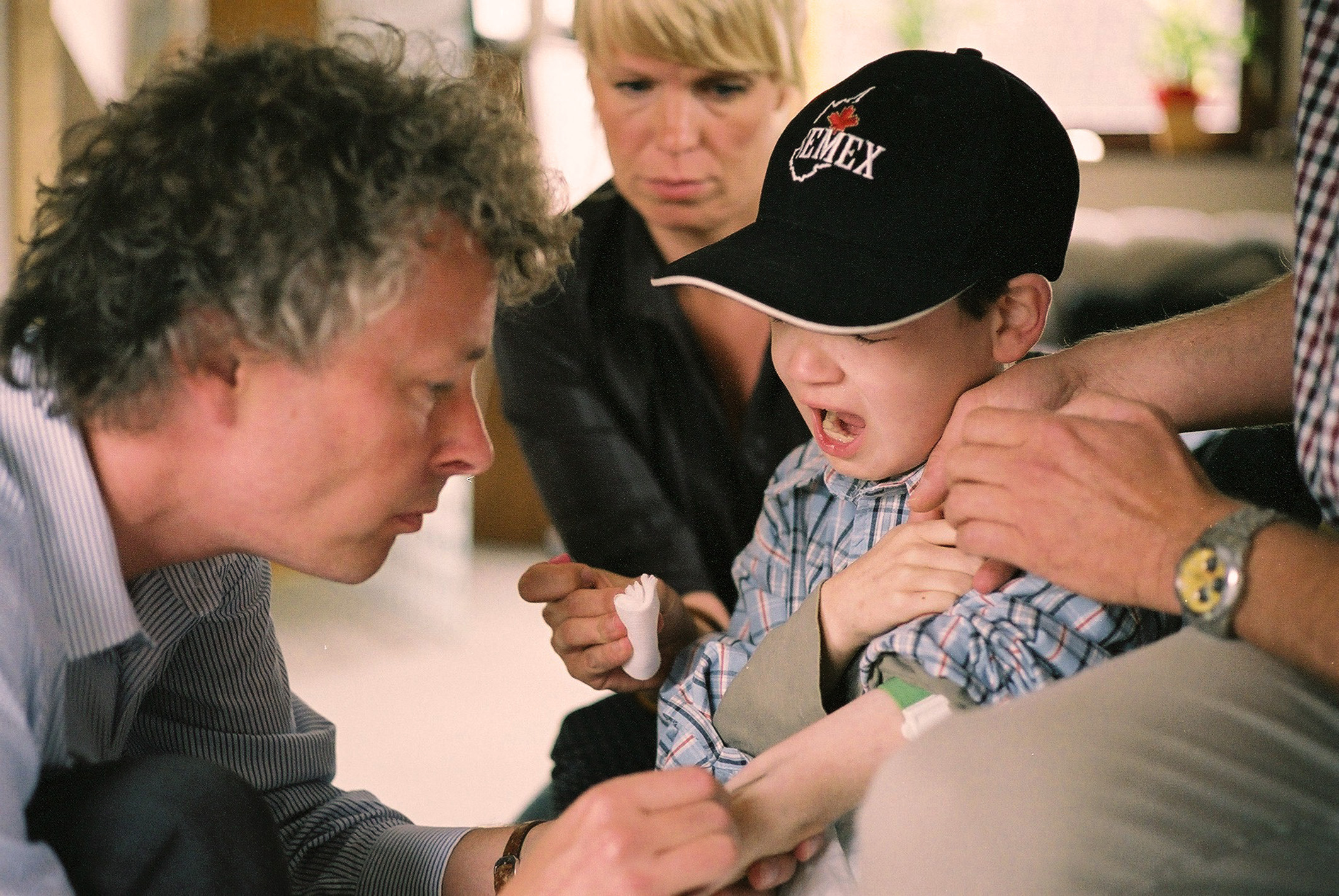 PD Dr. Boris Zernikow (l. ), leitender Arzt am Institut für Kinderschmerztherapie und pädiatrische Palliativmedizin der Vestischen Kinder- und Jugendklinik Datteln versucht mit Hilfe der Kinderkrankenschwester Dorothea van Üüm dem krebskranken Grundschüler Kersten Dirsus eine Kanüle zu legen. Im Anschnitt rechts der Vater des Jungen, Uwe Dirsus.  